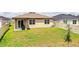 Spacious backyard featuring a covered patio, privacy fence, and lush lawn at 297 Spirit Landings Cir, Winter Haven, FL 33880