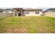 Backyard with a green lawn, fence, patio, and partial view of the home's exterior at 297 Spirit Landings Cir, Winter Haven, FL 33880