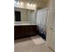Bathroom with double sinks, granite countertop, framed mirror, and decorative shower curtain at 297 Spirit Landings Cir, Winter Haven, FL 33880