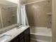 Bathroom with double sinks, granite countertops, and a tub with tiled walls and a shower at 297 Spirit Landings Cir, Winter Haven, FL 33880