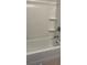 Clean white bathtub and shower with built-in shelving and chrome fixtures at 297 Spirit Landings Cir, Winter Haven, FL 33880