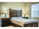 Bedroom with a wooden frame bed, tile floor, two side tables, and lamps at 297 Spirit Landings Cir, Winter Haven, FL 33880