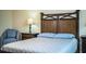Bedroom with a wooden bed frame, side tables with lamps, chair and tile flooring throughout at 297 Spirit Landings Cir, Winter Haven, FL 33880