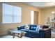 Comfortable living room with a modern couch, decorative pillows, and views into the dining area at 297 Spirit Landings Cir, Winter Haven, FL 33880