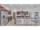 Modern kitchen features dark cabinetry, granite countertops, stainless steel appliances, and a spacious island with seating at 2991 Flying Blackbird Rd, Bartow, FL 33830
