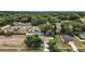 Aerial view of a home and property in a neighborhood surrounded by lush greenery at 305 Woods Landing Dr, Lady Lake, FL 32159
