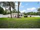 A green backyard featuring a screened-in lanai and a white vinyl privacy fence at 305 Woods Landing Dr, Lady Lake, FL 32159