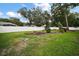 Spacious backyard with lush lawn, landscaping and a white vinyl privacy fence at 305 Woods Landing Dr, Lady Lake, FL 32159