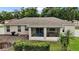 Home's backyard features a covered patio with a hot tub and outdoor seating area at 305 Woods Landing Dr, Lady Lake, FL 32159