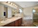 Bathroom featuring double sinks, large mirror, separate shower, and soaking tub at 305 Woods Landing Dr, Lady Lake, FL 32159