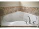 A close-up shot of a soaking tub featuring designer tile and a chrome faucet at 305 Woods Landing Dr, Lady Lake, FL 32159
