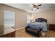 Comfortable bedroom features a ceiling fan, window with blinds, and hardwood floors at 305 Woods Landing Dr, Lady Lake, FL 32159