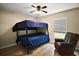 This bedroom contains a bunk bed, chair, and window with blinds at 305 Woods Landing Dr, Lady Lake, FL 32159