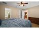 Large primary bedroom showing hardwood floors, a ceiling fan and views to the bath and kitchen at 305 Woods Landing Dr, Lady Lake, FL 32159