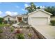 Inviting single-story home boasts lush landscaping, sidewalk and a two-car garage at 305 Woods Landing Dr, Lady Lake, FL 32159