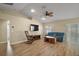 Living room features a ceiling fan, rocking chair, large tv, and a blue couch at 305 Woods Landing Dr, Lady Lake, FL 32159