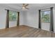 Comfortable bedroom featuring wood-look floors, a ceiling fan, and windows with backyard views at 317 S 8Th St, Haines City, FL 33844