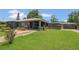 Charming home featuring a spacious front yard and a covered porch, complemented by lush landscaping and mature trees at 317 S 8Th St, Haines City, FL 33844
