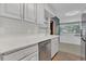 Bright kitchen featuring white cabinets, a stainless steel dishwasher and sink, complemented by modern finishes at 317 S 8Th St, Haines City, FL 33844