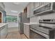 Modern kitchen featuring stainless steel appliances, gray cabinets, and views of the backyard from the window at 317 S 8Th St, Haines City, FL 33844