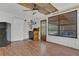 Bright living room featuring wood floors, brick walls, a ceiling fan, and black-framed windows offering natural light at 317 S 8Th St, Haines City, FL 33844