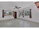 Bright living room featuring tile flooring, neutral walls, ceiling fan and large windows with outdoor views at 317 S 8Th St, Haines City, FL 33844