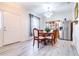 Bright dining room with new light gray floors, stainless steel refrigerator and wooden dining set at 3281 Enclave Blvd, Mulberry, FL 33860