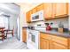 Well-lit kitchen with light oak cabinets, light gray floors, and stainless steel appliances at 3281 Enclave Blvd, Mulberry, FL 33860