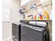 Well-organized laundry room with modern gray washer and dryer, and ample shelf storage at 3281 Enclave Blvd, Mulberry, FL 33860