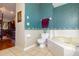 A large beige tub situated in bathroom featuring patterned wallpaper and tile flooring at 330 W Palmetto St, Lakeland, FL 33815