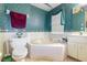 A large beige tub situated in bathroom featuring patterned wallpaper and tile flooring at 330 W Palmetto St, Lakeland, FL 33815