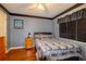 A bedroom with a gray and black bedding on a queen bed, wood flooring and a ceiling fan at 330 W Palmetto St, Lakeland, FL 33815