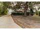 Two-story home with covered porch and a long driveway leading to a garage and vehicle at 330 W Palmetto St, Lakeland, FL 33815