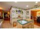 Cozy kitchen area with a sink, breakfast bar, decorative wallpaper, and open access to dining and living spaces at 330 W Palmetto St, Lakeland, FL 33815
