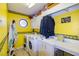 Bright laundry room with washer, dryer, utility sink, storage cabinets, and unique decorative elements at 330 W Palmetto St, Lakeland, FL 33815