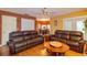 View of the living room leading into the dining area, featuring leather couches and wood floors at 330 W Palmetto St, Lakeland, FL 33815