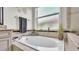 Bathroom features a garden tub with tile surround and a large picture window for natural light at 3926 Aquilla Dr, Lakeland, FL 33810
