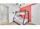 bedroom with bunkbeds, red accent wall, window, and toy chest at 3926 Aquilla Dr, Lakeland, FL 33810