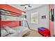 bedroom with bunkbeds, red accent wall, window, and toy chest at 3926 Aquilla Dr, Lakeland, FL 33810