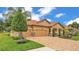 Beautiful home with a well-maintained lawn, paver driveway, and lush landscaping at 3926 Aquilla Dr, Lakeland, FL 33810