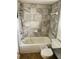 Bathroom featuring tiled walls, a shower-tub combo, and a toilet at 4038 Lehman Ln, Lakeland, FL 33813