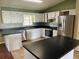 Kitchen features white cabinets, black countertops, and stainless steel appliances at 4038 Lehman Ln, Lakeland, FL 33813