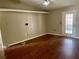 Open living room features hardwood floors, ceiling fan, and a glass-paneled back door at 4038 Lehman Ln, Lakeland, FL 33813