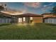 Large backyard featuring a screened lanai, lush green grass, and white vinyl fencing at 4088 Prima Lago Cir, Lakeland, FL 33810