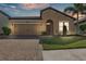 Charming single-story home boasts a well-manicured lawn, tiled roof, and brick-paved driveway at 4088 Prima Lago Cir, Lakeland, FL 33810