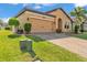 Beautiful home featuring a brick paver driveway, lush landscaping, and an attached two-car garage at 4088 Prima Lago Cir, Lakeland, FL 33810