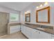 Bright primary bathroom features double sinks, granite counters, soaking tub, and walk-in shower at 4088 Prima Lago Cir, Lakeland, FL 33810