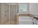 Luxurious primary bathroom featuring a soaking tub and a separate tiled shower with modern fixtures at 4088 Prima Lago Cir, Lakeland, FL 33810