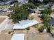 An aerial view of a home with a metal roof, mature trees, and surrounded by a spacious yard at 415 Manor Dr, Bartow, FL 33830