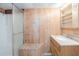 Bathroom features wood paneling, shower, vanity and sink with built-in storage and a seating area at 415 Manor Dr, Bartow, FL 33830